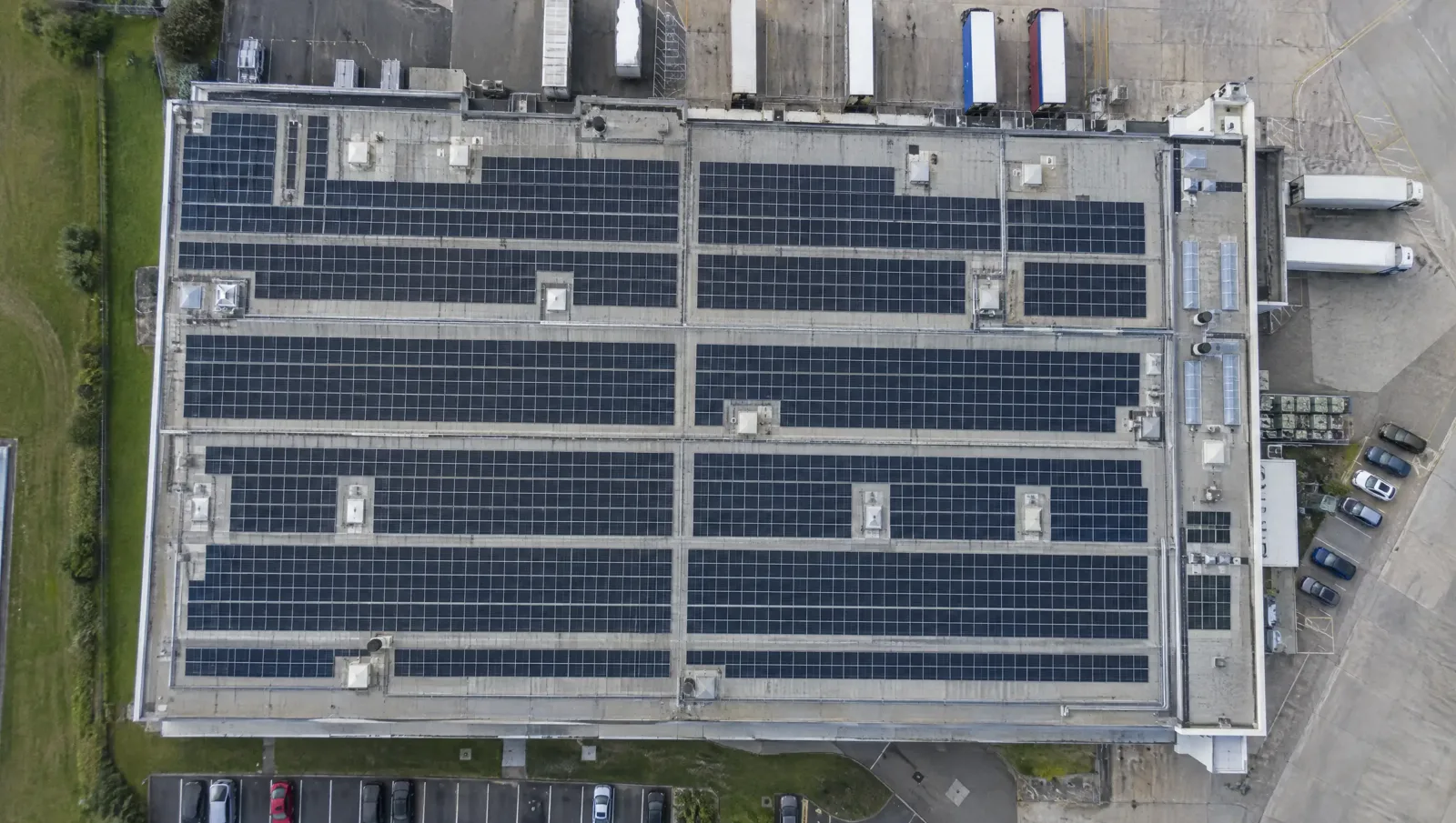 Top-down view of rows of solar panels on an industrial roof